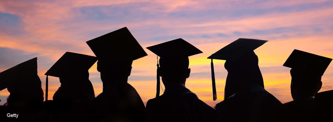 Silhouettes of students with graduate caps and gowns
