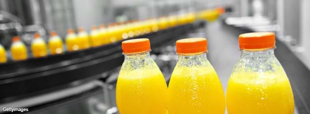 Orange juice bottles on factory assembly line