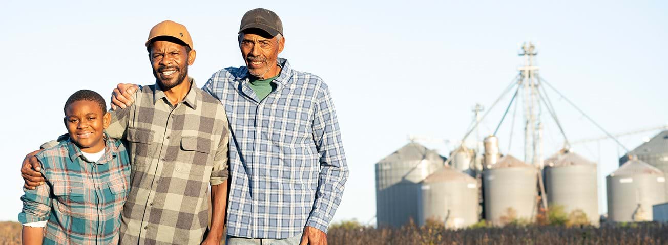 Family of farmers in front of silos