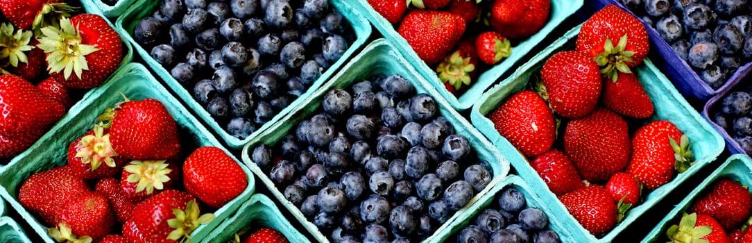 Photo of strawberries and blueberries in packing crates ready for sale